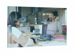 Collaborating teen and mentor viewing code overlays at open workspace, with laptop and smartphone