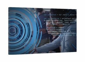 Leaning man in light buttondown shirt turning toward desk at office pointing at laptop, HUD overlay