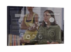 Seated woman in green shirt gesturing while reviewing data at open-plan office, with HUD overlay
