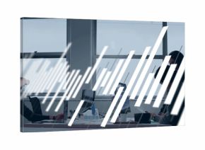 Working coworkers sitting at shared office desk, typing on laptops with coffee cup and notebooks