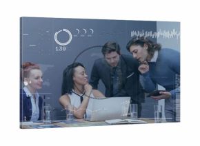 Analyzing data, four colleagues in suits leaning over laptop at meeting table, with HUD overlays