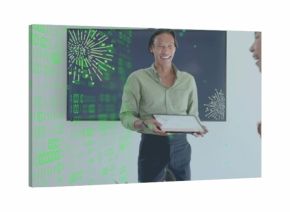 Presenting man in light green shirt with tablet at office, screen with green fireworks overlay
