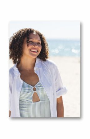 Young biracial woman enjoys a sunny beach day