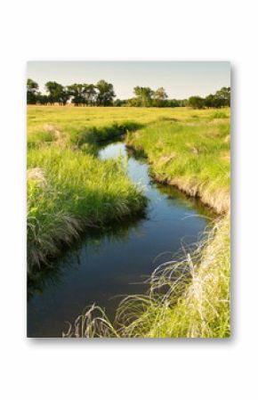 creek winding through Kansas pasture field