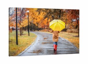 Woman with umbrella taking walk in autumn park on rainy day