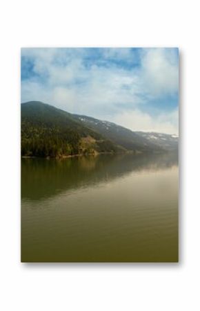 Mountain range reflecting on river against sky