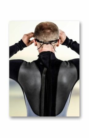 Rear view of male swimmer wearing swimming goggles at beach
