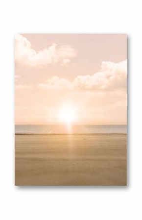 Bright sun disk is casting golden glow over sand, sea under cloud-speckled sky in flat design