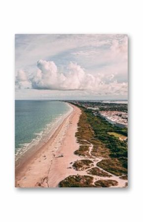 Drone shot of Cape Canaveral cityscape by the beach under cloudy sky in Florida
