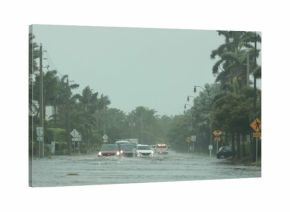 Flooded road with cars passing through during hurricane Nicole in Palm Beach, Florida. November 2022