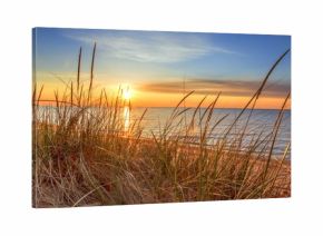 Dawn Of A New Day.Beautiful sunrise illuminates  sand dunes and the blue water horizon as a new day begins. Port Austin, Michigan.