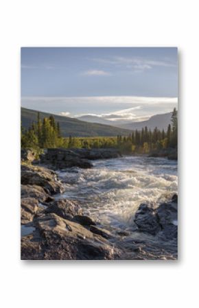 Golden light shining on wild river flowing down the beautiful Swedish landscape