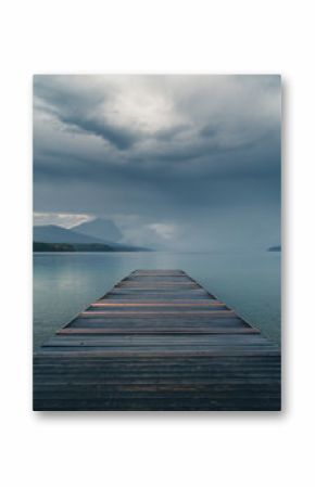 Dock overlooking a calm overcast lake.