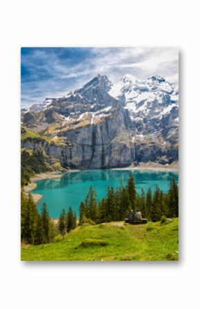 Amazing tourquise Oeschinnensee with waterfalls, wooden chalet and Swiss Alps, Berner Oberland, Switzerland.