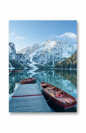 Klarer Gebirgssee mit Booten und Steg  vor felsiger Gebirgslandschaft 