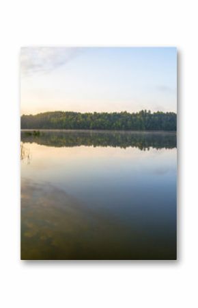 Wilderness Lake Sunrise. Sunlight glows over the horizon of a wilderness lake in northern Michigan. Horizontal orientation with copy space in the foreground.