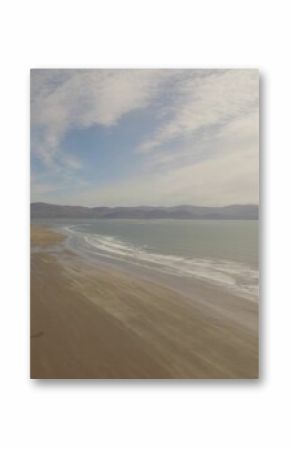Sea shore against cloudy sky