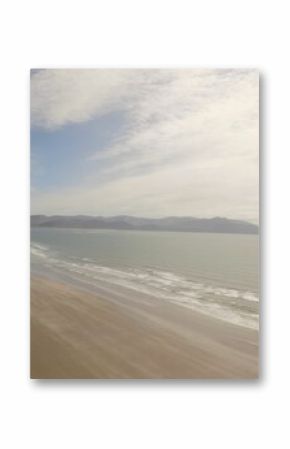 Sea shore against cloudy sky