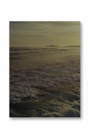 Rolling foamy ocean waves catching golden sunset light at beach viewpoint, coastal seascape