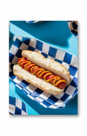 High angle close-up of hot dogs in containers arranged on blue background