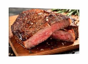 Medium Rare Ribeye steak on wooden board, selected focus