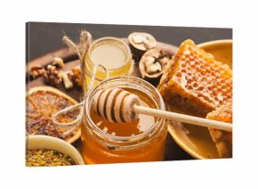 Various types of honey on wooden platter, closeup