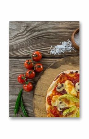 Pizza by spices on wooden table