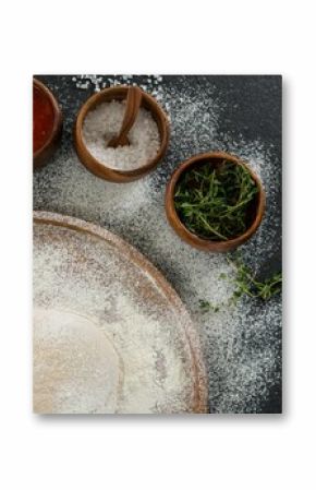 Pizza dough with ingredients on table