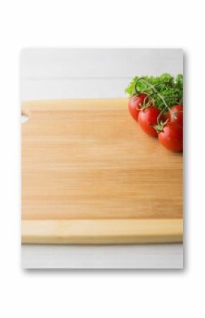 Tomatoes with parsley and chopping board on hardwood floor