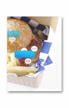Displaying takeout box holding burger and fries on kitchen countertop with chat bubbles, copy space