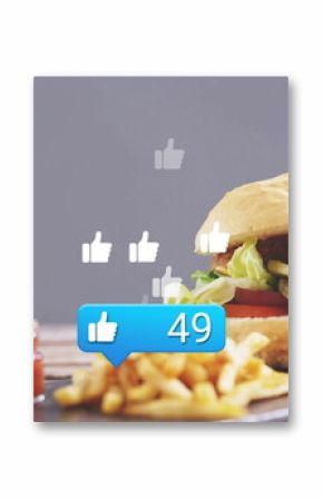 Highlighting cheeseburger on board in studio with fries and ketchup, thumbs-up bubble, copy space
