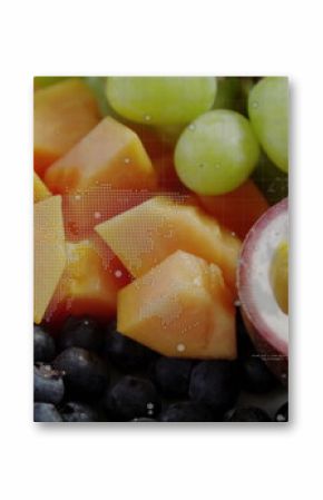Displaying papaya cubes, grapes, blueberries, halved passion fruit on studio table with map overlay