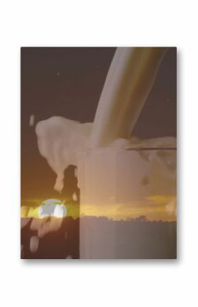 Pouring milk stream into clear glass, frothing overflow on rural horizon at sunset with tree line
