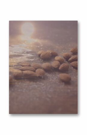 Shimmering raw almonds resting on polished wooden tabletop, with sugar-like granules