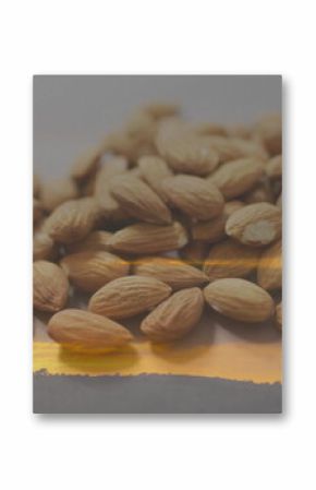 Displaying heap of tan whole almonds reflecting on smooth tabletop, with sunset hill silhouette
