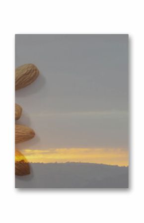 Presenting almond shells blending on tabletop and hills, with orange horizon and cloudy sky