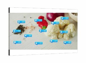 Arranging cauliflower florets with red pepper slices, legumes on kitchen table with social icons
