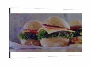 Displaying three mini cheeseburgers sitting on wooden tabletop with french fries and glitch effects
