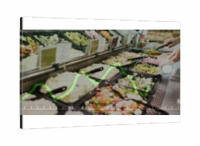 Grabbing hand selecting fresh salad ingredients at cafeteria bar with metal tongs and data overlay