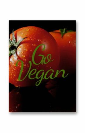 Image of go vegan text over tomatoes on black background