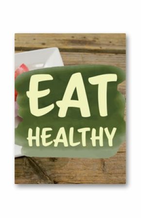 Image of eat healthy text over pomegranate on plate on table