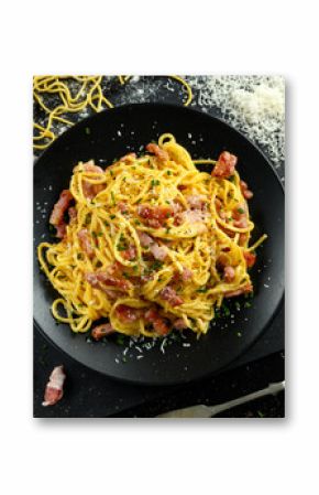 Classic Homemade Pasta carbonara Italian with Bacon, eggs, Parmesan Cheese on black plate.