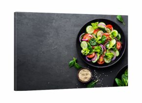 Healthy vegetable salad of fresh tomato, cucumber, onion, spinach, lettuce and sesame on plate. Diet menu. Top view.