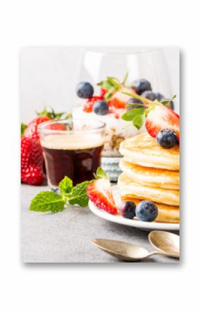 Breakfast composition with fresh pancakes and berries on light gray concrete background. Healthy food concept with copy space. Banner.