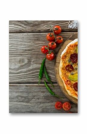 Pizza by tomatoes on wooden table