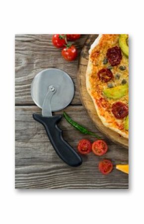 Pizza on by cutter on wooden table
