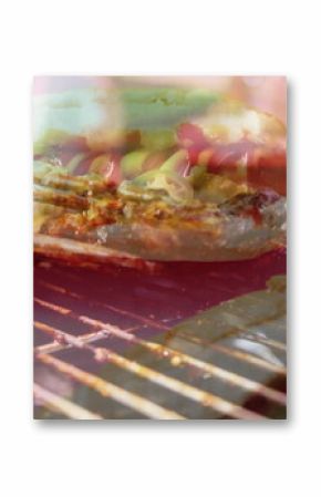Grilling hot dog bun with cheese, jalapeños on grill in backyard, alongside sausages and meat slab