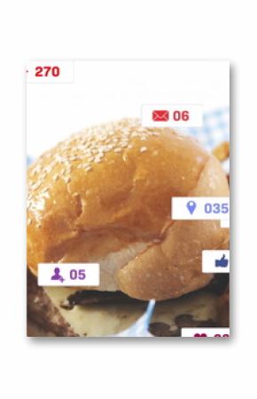 Sesame burger bun resting atop patty with melted cheese in basket on table, fries, chicken, icons