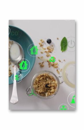 Featuring turquoise bowl with granola and berries on tabletop with floating eco icons, copy space