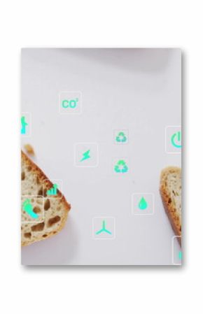 Displaying crusty artisan bread slices on white table with floating environmental icons and crumbs